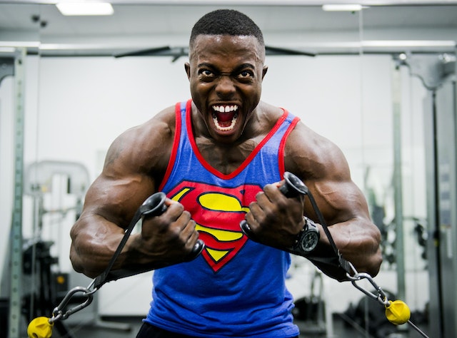 Mann som motiverer seg selv til å trene i en supermann skjorte