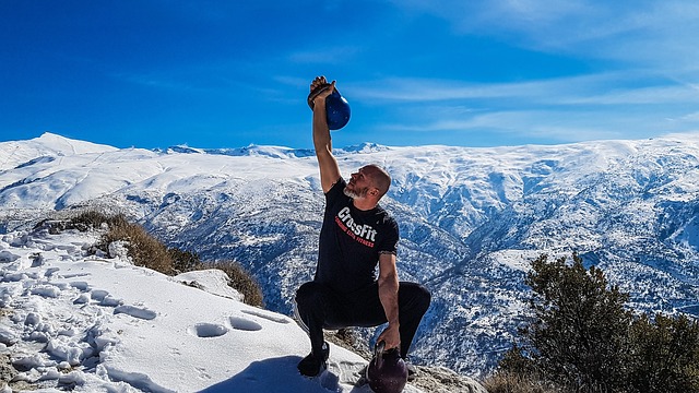 Mann som trener med kettlebells på fjellet