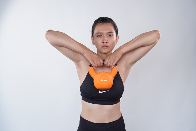 Kvinne som trener skuldre med kettlebells